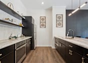 Thumbnail 47 of 57 - A kitchen with black cabinets and a white counter top.