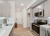 Thumbnail 12 of 24 - Renovated kitchen with white cabinets and stainless steel appliances at The Anchorage on Kelly, East Falls, Pennsylvania