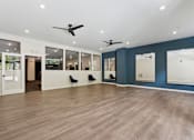 Thumbnail 54 of 57 - A spacious room with wooden floors and ceiling fans.