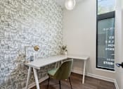 Thumbnail 46 of 57 - A white desk with a green chair in front of a wall with a mosaic of buildings.