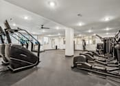 Thumbnail 52 of 57 - A gym with treadmills, elliptical machines, and a fan.