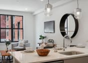 Thumbnail 3 of 24 - Kitchen and living room with white walls and a large window  at The Anchorage on Kelly, East Falls, PA