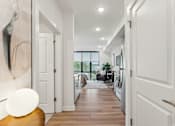 Thumbnail 44 of 57 - A hallway with white doors and a wooden floor.