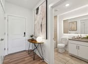 Thumbnail 24 of 57 - A bathroom with a toilet, sink, and a painting on the wall.