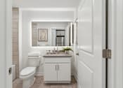 Thumbnail 25 of 57 - A white bathroom with a toilet, sink, and cabinet.