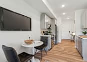 Thumbnail 21 of 57 - A modern kitchen with a dining table and chairs.