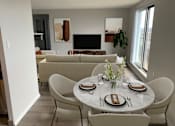 Thumbnail 6 of 20 - a living room and dining room with a table and chairs