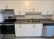 Thumbnail 8 of 20 - a kitchen with white cabinets and stainless steel appliances and a sink