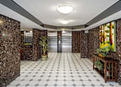 Thumbnail 18 of 20 - a lobby with a white tile floor and marble walls