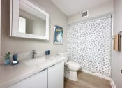 Thumbnail 8 of 25 - a bathroom with a shower and a toilet and a sink