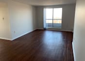 Thumbnail 14 of 20 - an empty living room with wood floors and a window