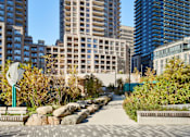 Thumbnail 1 of 24 - A cityscape with tall buildings and a clear blue sky.