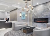 Thumbnail 5 of 24 - A modern office lobby with a reception desk and a fireplace.