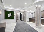 Thumbnail 4 of 24 - A reception area with a green sign with a white letter B on it.