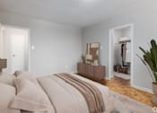 Thumbnail 4 of 12 - A bedroom with a large bed and a wooden dresser.
