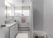 Thumbnail 8 of 12 - A white bathroom with a window and a sink.