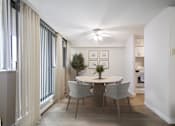 Thumbnail 2 of 11 - A dining room with a table and chairs.