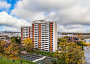 Thumbnail 9 of 11 - A tall apartment building with a tennis court in front of it.