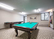Thumbnail 7 of 11 - A pool table in a room with a picture on the wall.
