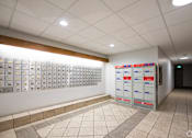 Thumbnail 8 of 11 - A hallway with a row of mailboxes on the wall.