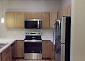 Thumbnail 9 of 19 - A kitchen with a stainless steel refrigerator, sink, and stove.