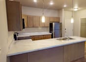 Thumbnail 10 of 19 - A kitchen with a sink and a refrigerator.