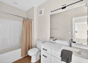 Thumbnail 18 of 19 - A white bathroom with a toilet, sink, and shower.
