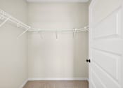 Thumbnail 15 of 19 - A white closet with a white door and a white shelf.