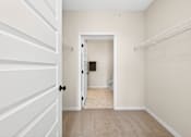 Thumbnail 10 of 19 - A white door is open to a small bathroom.