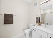 Thumbnail 16 of 19 - A white bathroom with a toilet, sink, and mirror.