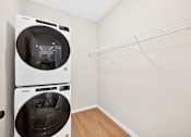 Thumbnail 17 of 19 - A laundry room with a white dryer and washer.