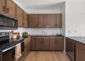 Thumbnail 20 of 25 - A kitchen with brown cabinets and a black stove top.