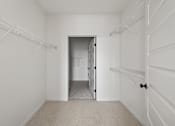 Thumbnail 4 of 25 - A white room with a doorway leading to another room.