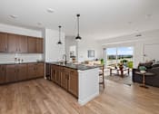 Thumbnail 5 of 21 - A modern kitchen with wooden floors and a large island.