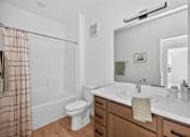 Thumbnail 22 of 25 - A bathroom with a toilet, sink, and mirror.