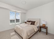 Thumbnail 12 of 25 - A bedroom with a large bed and a window with blinds.