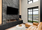 Thumbnail 36 of 61 - A modern living room with a fireplace and a flat screen TV.