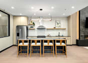 Thumbnail 34 of 61 - A modern kitchen with a large island and wooden bar stools.