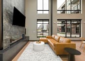 Thumbnail 37 of 61 - A modern living room with a fireplace and a large flat screen TV mounted on the wall.