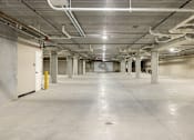 Thumbnail 61 of 61 - A large, empty, industrial-style room with white walls and a concrete floor.