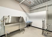 Thumbnail 59 of 61 - A large industrial metal container is in a room with a table and a fence.