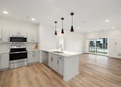 Thumbnail 48 of 61 - A kitchen with white cabinets and a wooden floor.