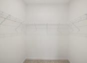 Thumbnail 57 of 61 - A white room with a wire shelving unit and a carpeted floor.