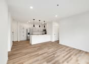 Thumbnail 47 of 61 - A kitchen with a white counter and wooden floors.