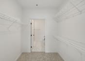 Thumbnail 53 of 61 - A white closet with a carpeted floor and a door.
