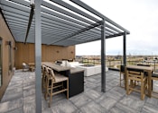 Thumbnail 45 of 61 - A patio with a table and chairs under a roof.
