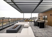 Thumbnail 46 of 61 - A patio with a fire pit and seating area.