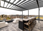 Thumbnail 44 of 61 - A patio with a table and chairs overlooking a city.