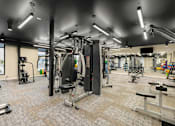 Thumbnail 41 of 61 - A gym with a variety of equipment including a squat rack, a leg press machine, and a bench press.