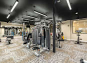 Thumbnail 43 of 61 - A gym with a variety of equipment including a squat rack, leg press, and a bench press.